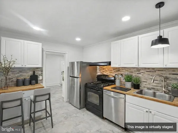 a kitchen with stainless steel appliances kitchen island a refrigerator and a sink