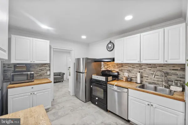 a kitchen with stainless steel appliances granite countertop a refrigerator and a stove top oven