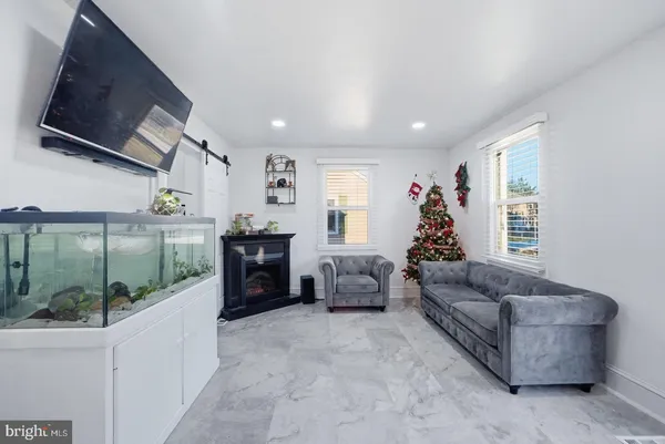 a living room with furniture flat screen tv and a large window