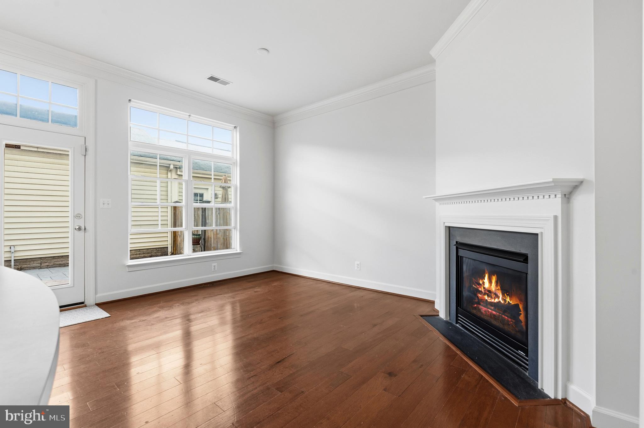 9227 Ribbon Falls Loop Bristow, VA 20136 - Photo 26 of 53 a view of an empty room with wooden floor fireplace and a window