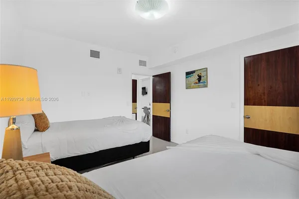 a bedroom with a bed and painting on the wall