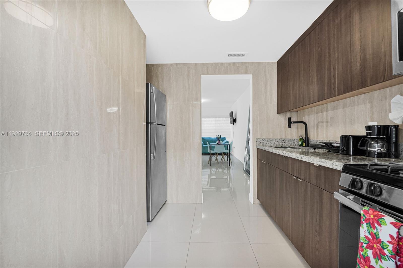 1025 94th Street, Unit 9 Bay Harbor Islands, FL 33154 - Photo 11 of 21 a kitchen with stainless steel appliances a refrigerator and a sink