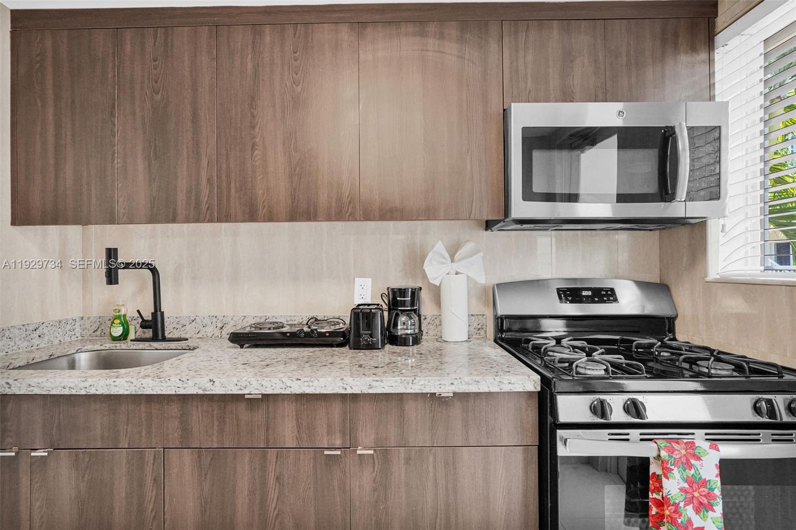 1025 94th Street, Unit 9 Bay Harbor Islands, FL 33154 - Photo 12 of 21 a kitchen with granite countertop a stove and a sink