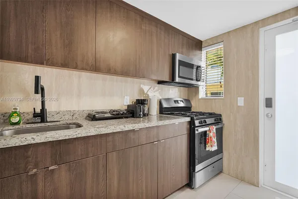 a kitchen with stainless steel appliances granite countertop a sink stove and microwave
