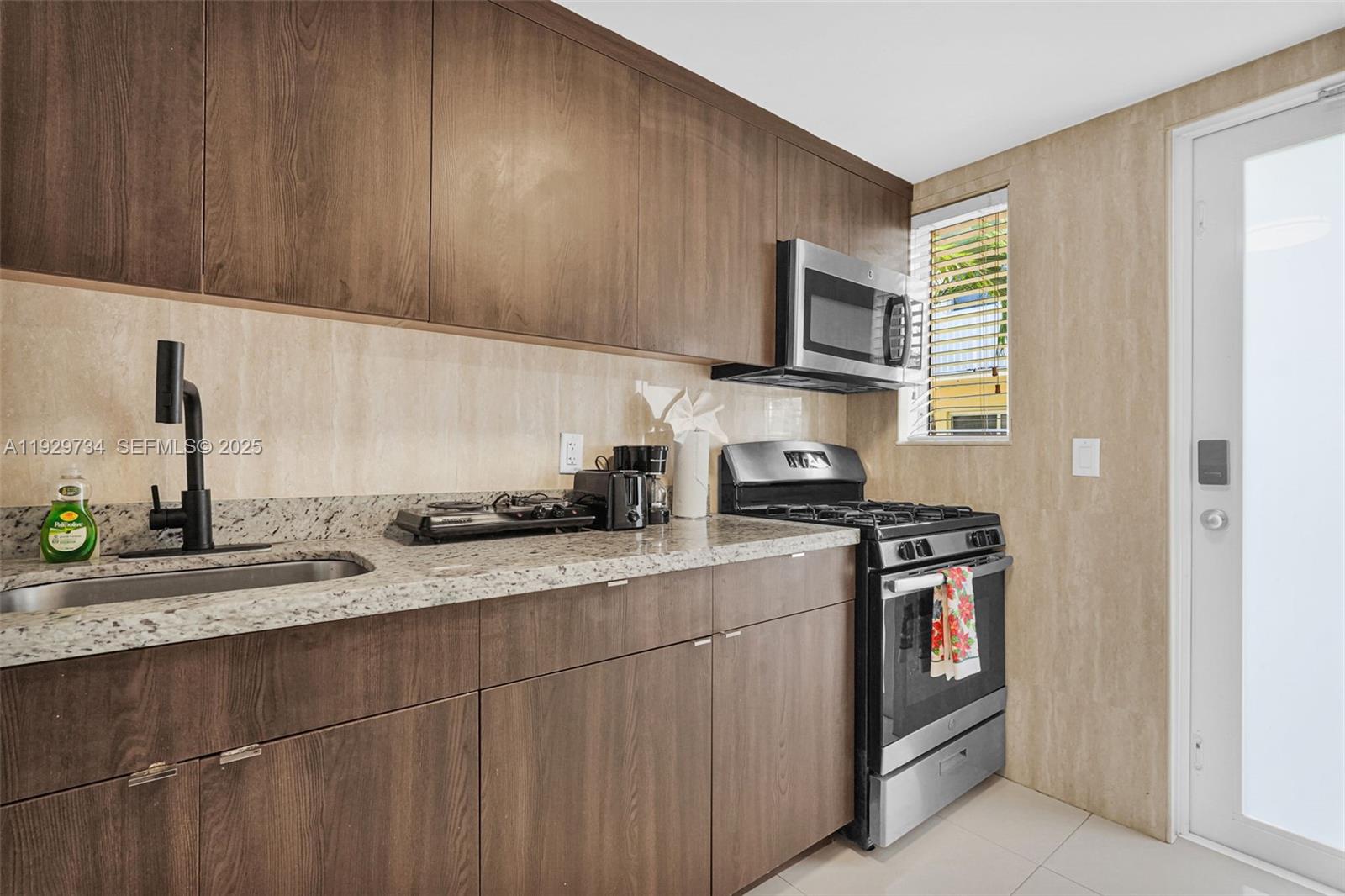 1025 94th Street, Unit 9 Bay Harbor Islands, FL 33154 - Photo 13 of 21 a kitchen with stainless steel appliances granite countertop a sink stove and microwave