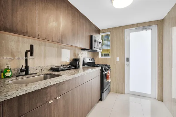 a kitchen with stainless steel appliances granite countertop a sink stove and cabinets