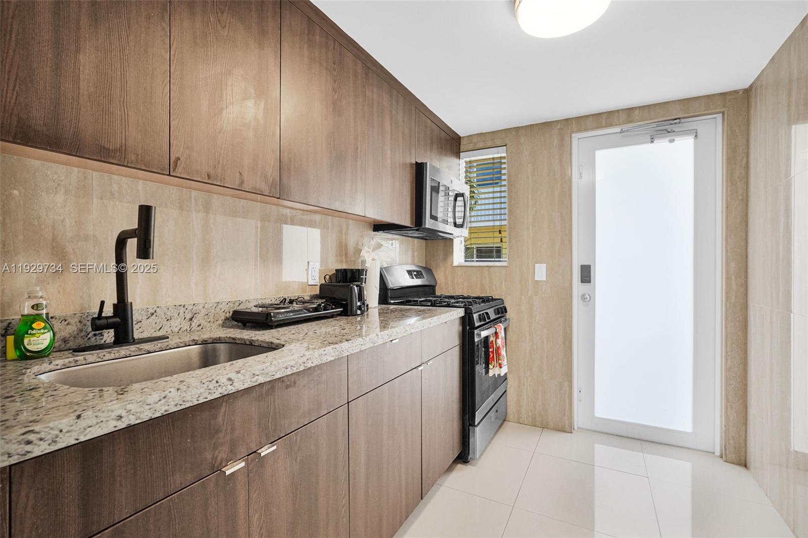 1025 94th Street, Unit 9 Bay Harbor Islands, FL 33154 - Photo 14 of 21 a kitchen with stainless steel appliances granite countertop a sink stove and cabinets