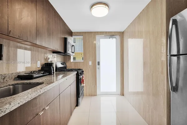 a kitchen with a sink a refrigerator and cabinets