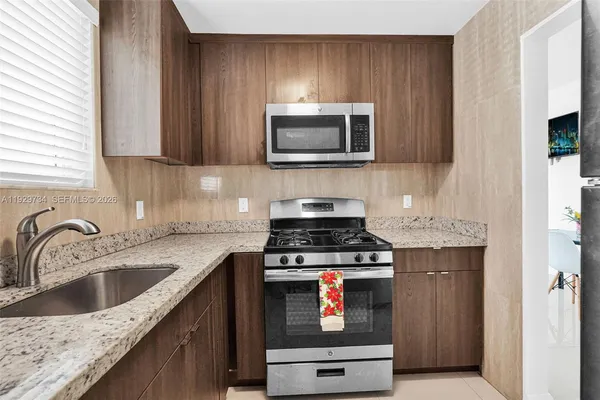 a kitchen with stainless steel appliances granite countertop a stove top oven microwave and cabinets