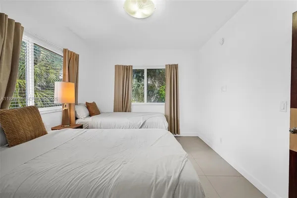 a bedroom with beds and a large window