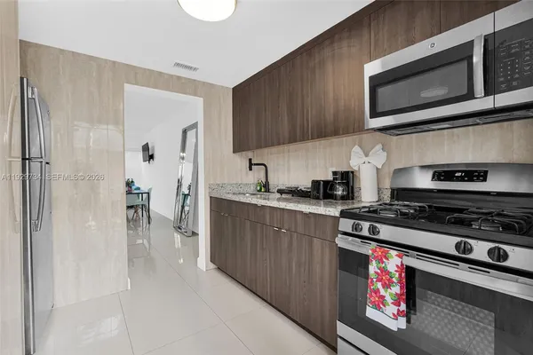 a kitchen with stainless steel appliances granite countertop a stove a microwave and a refrigerator