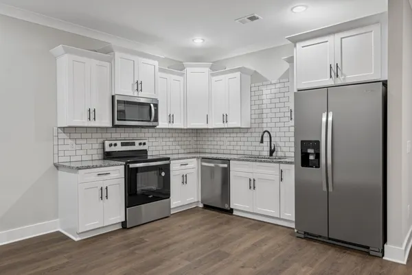 a kitchen with stainless steel appliances a refrigerator sink and microwave