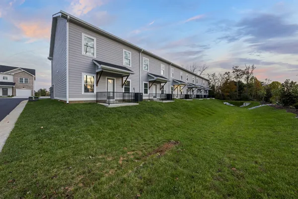a view of a house with a big yard and large trees