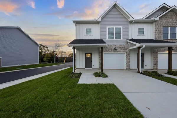 a front view of a house with yard and green space