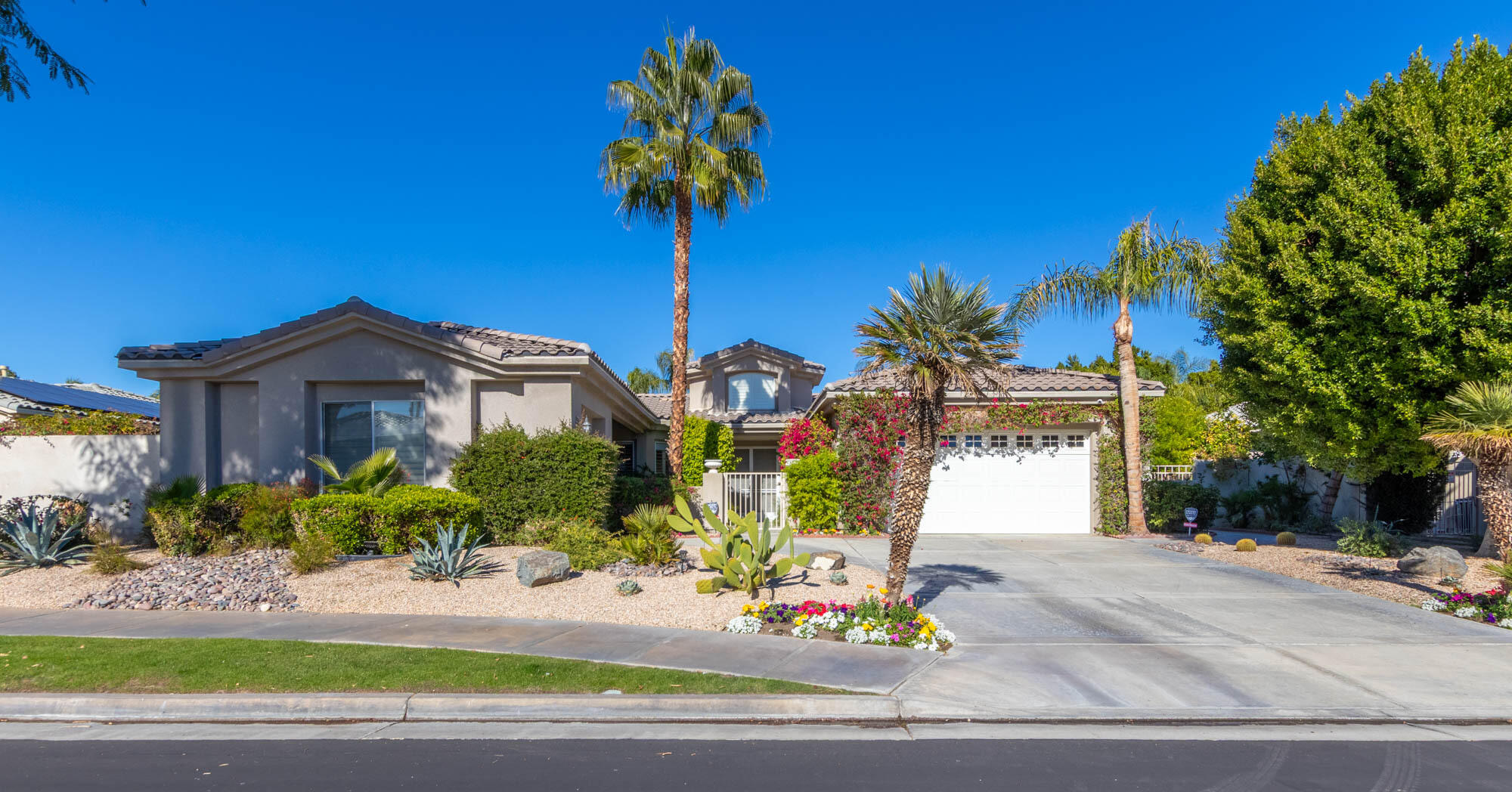 a front view of a house with a yard and potted plants