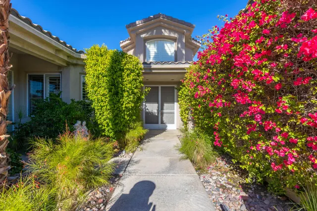 a front view of a house with a big yard and fountain
