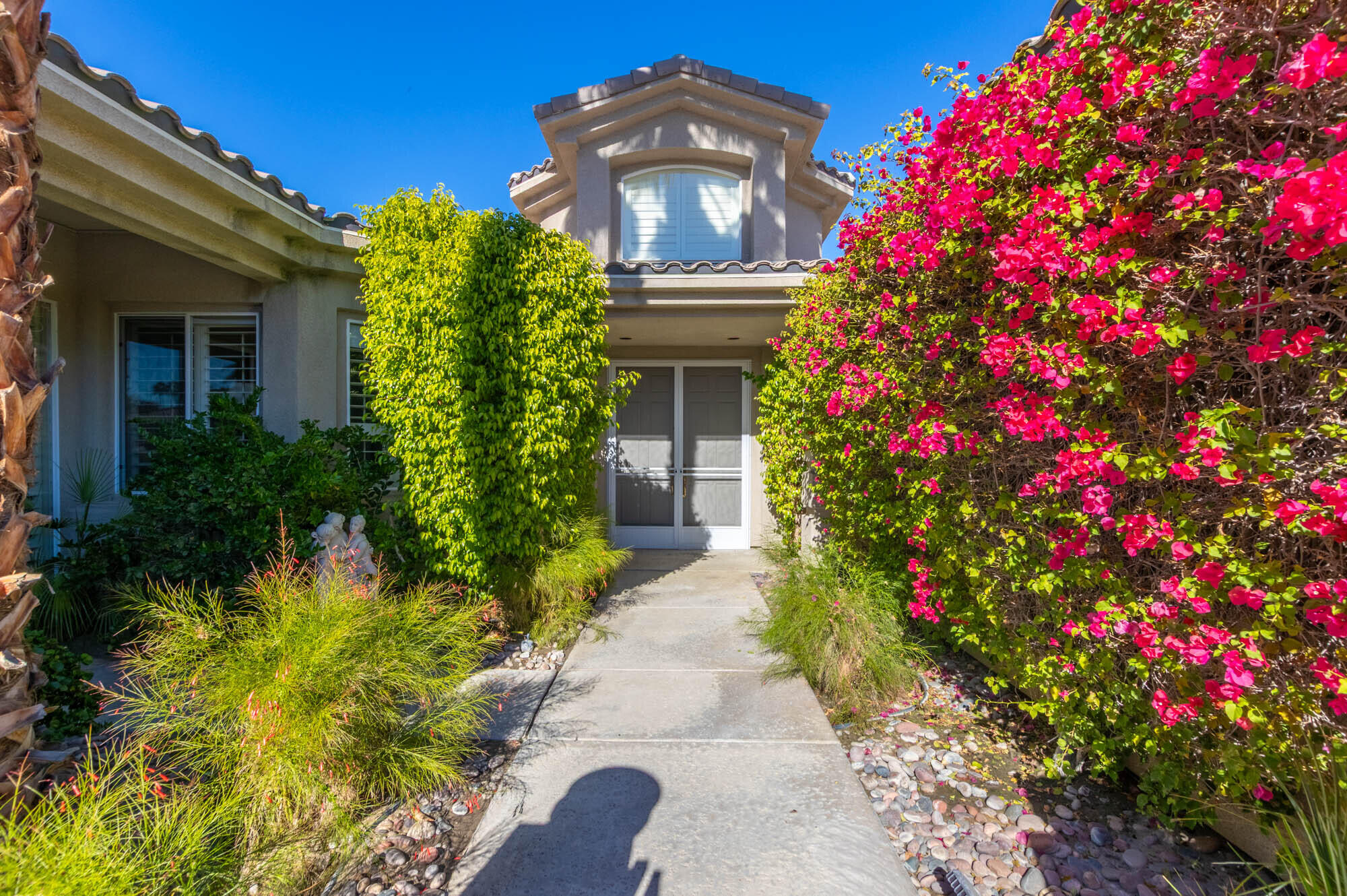 4 Bentley Road Rancho Mirage, CA 92270 - Photo 2 of 13 a front view of a house with a big yard and fountain