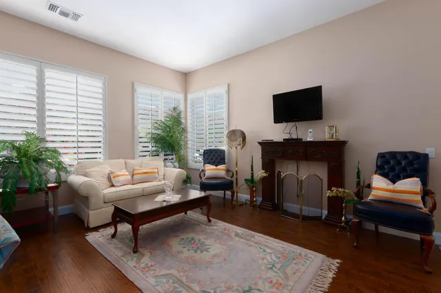a living room with furniture a flat screen tv and a fireplace