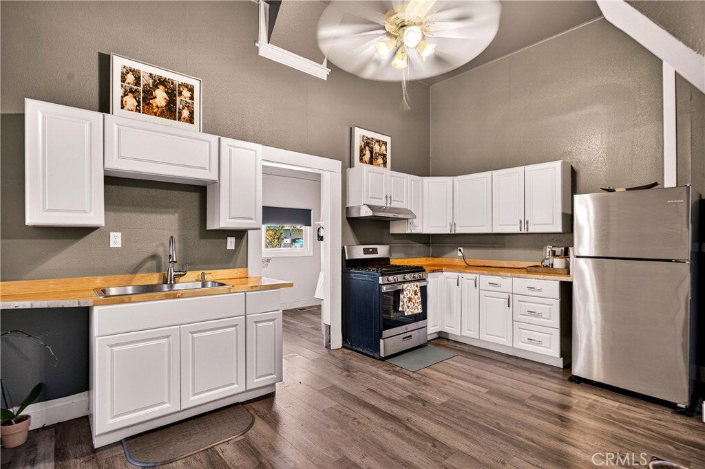 1214 Marin Street Corning, CA 96021 - Photo 13 of 57 a kitchen with a refrigerator and a stove top oven
