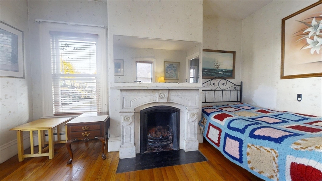 57 Church Street Watertown, MA 02472 - Photo 5 of 18 a bedroom with a bed and a fireplace