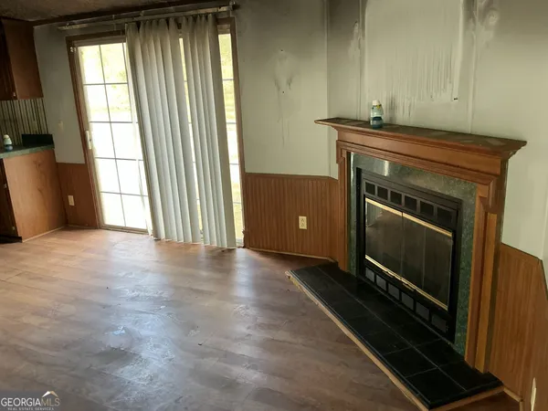 a view of an empty room with a fireplace and a window