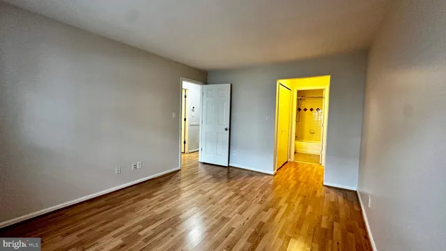a view of a room with wooden floor and a ceiling fan