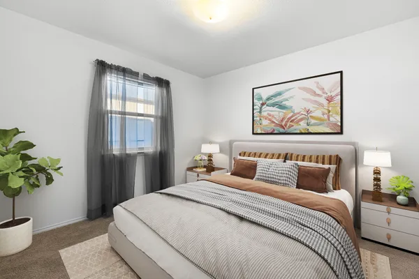 a bedroom with bed and a potted plant