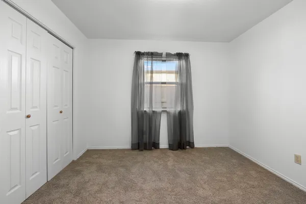 an empty room with closet and wooden door