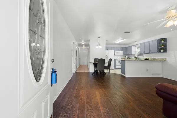 a living room with stainless steel appliances furniture and a kitchen view
