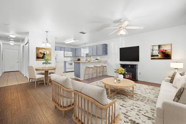 a living room with furniture a flat screen tv and kitchen view