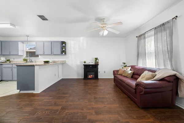 a living room with furniture and a wooden floor