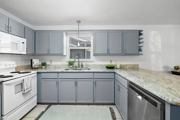 a kitchen with stainless steel appliances granite countertop a sink stove and cabinets