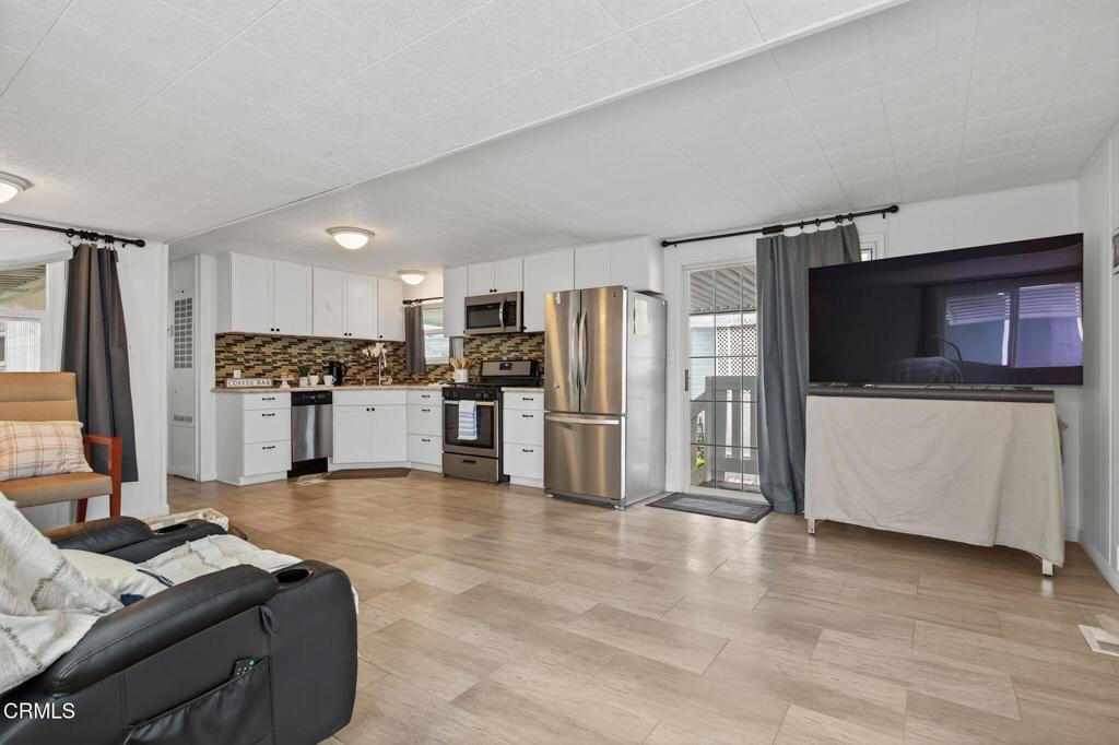 4032 Mockingbird Lane, Unit 4032 Oxnard, CA 93033 - Photo 12 of 36 a kitchen with stainless steel appliances kitchen island granite countertop a refrigerator and a stove top oven