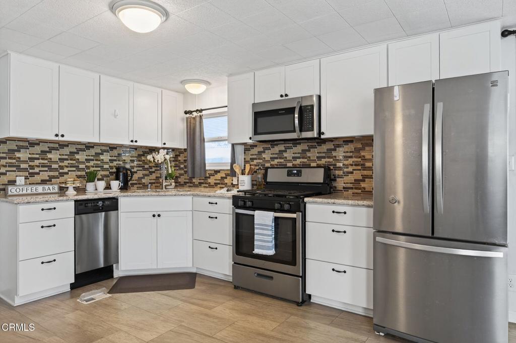 4032 Mockingbird Lane, Unit 4032 Oxnard, CA 93033 - Photo 16 of 36 a kitchen with stainless steel appliances white cabinets and a refrigerator