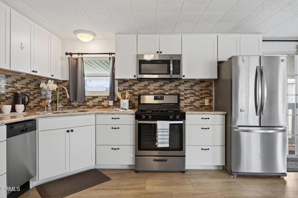 4032 Mockingbird Lane, Unit 4032 Oxnard, CA 93033 - Photo 17 of 36 a kitchen with stainless steel appliances white cabinets and a stove top oven