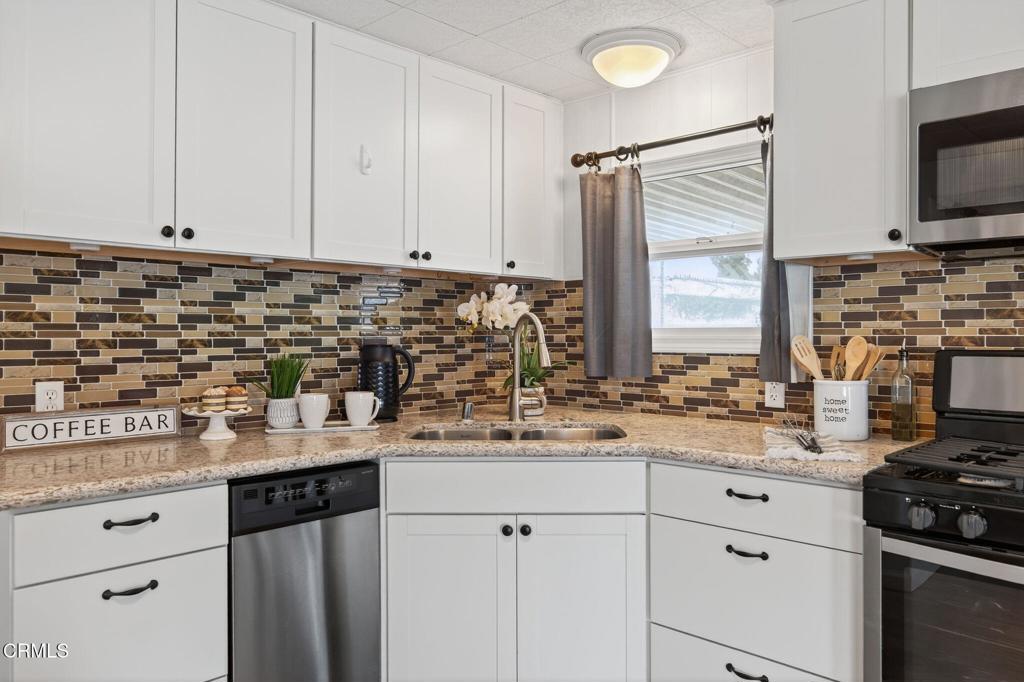 4032 Mockingbird Lane, Unit 4032 Oxnard, CA 93033 - Photo 18 of 36 a kitchen with stainless steel appliances granite countertop a sink stove and cabinets