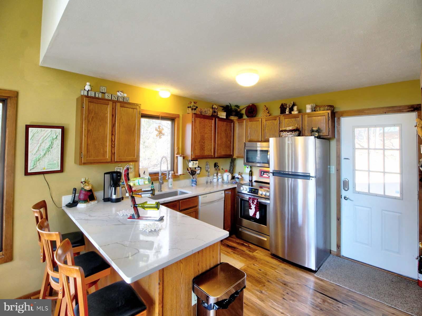 51 Forrest Street Basye, VA 22810 - Photo 14 of 27 a kitchen with a refrigerator a stove a sink dishwasher with a dining table and chairs