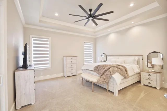 a bedroom with a bed a flat screen tv and a couch