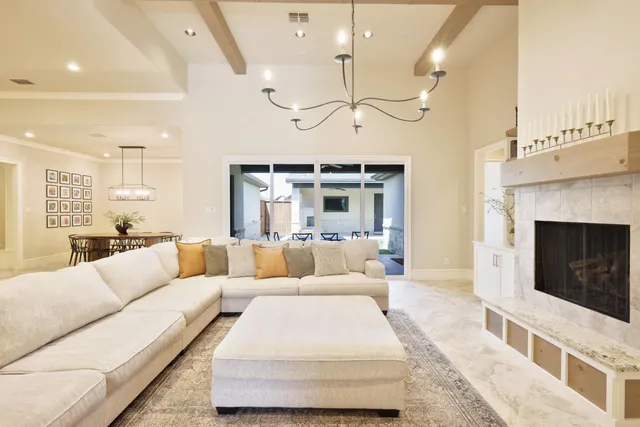 a living room with furniture a fireplace and a chandelier