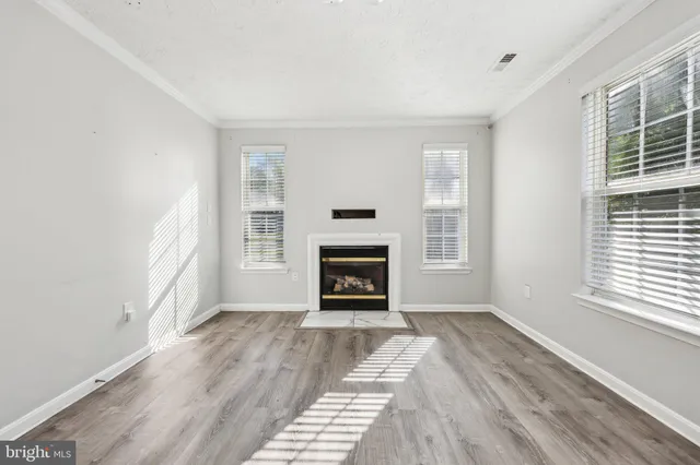 a view of an empty room with window and fire place