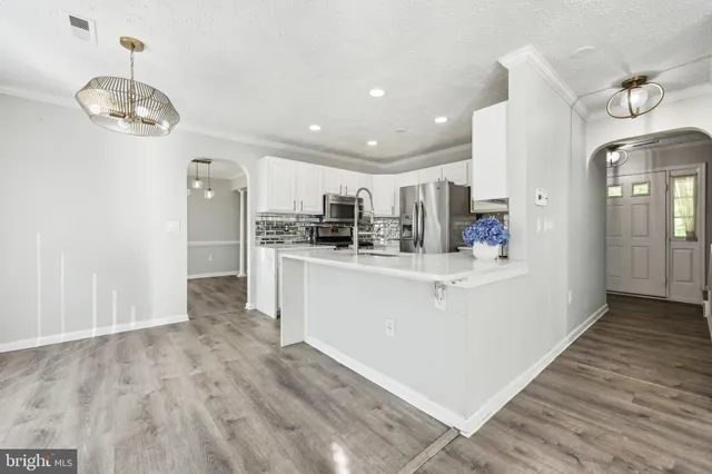 a view of kitchen with stainless steel appliances refrigerator stove microwave and cabinets