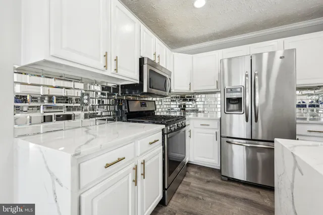 a kitchen with stainless steel appliances granite countertop a refrigerator sink and cabinets