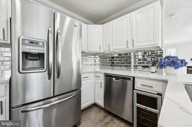 a kitchen with stainless steel appliances a refrigerator sink and cabinets