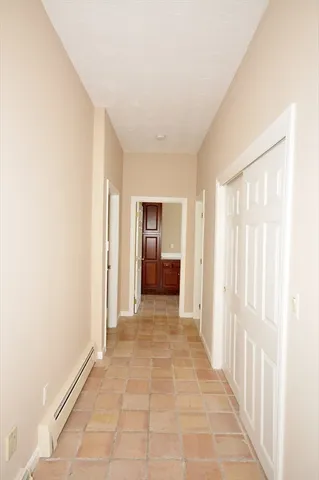 a view of a hallway with wooden shelves