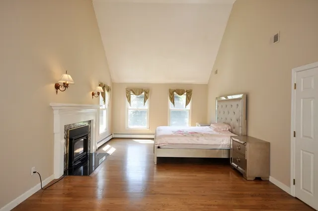 a spacious bedroom with a bed and a fireplace