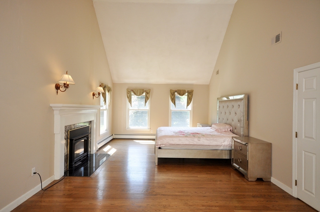 9 Breezy Point Road Acton, MA 01720 - Photo 21 of 37 a spacious bedroom with a bed and a fireplace