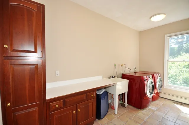 a utility room with stainless steel appliances granite countertop a refrigerator and a sink