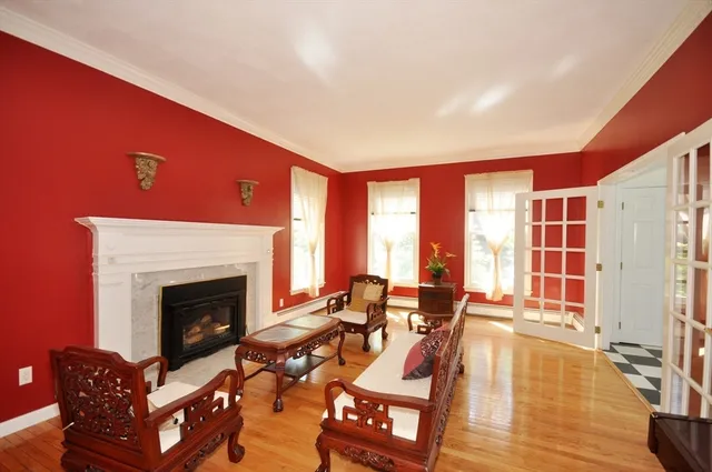 a living room with furniture a fireplace and floor to ceiling window