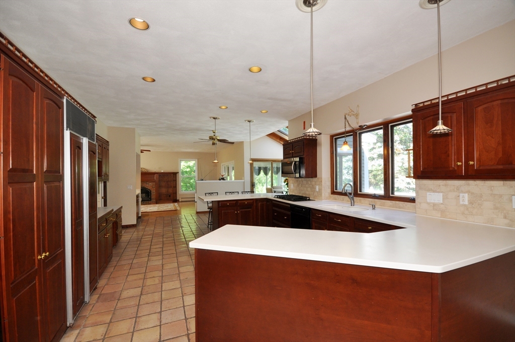 9 Breezy Point Road Acton, MA 01720 - Photo 10 of 37 a kitchen with stainless steel appliances kitchen island granite countertop a refrigerator and a sink