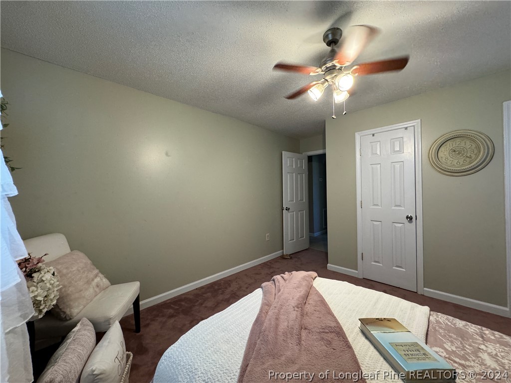 209 Old Farm Road Raeford, NC 28376 - Photo 26 of 45 a bedroom with a bed and a chandelier